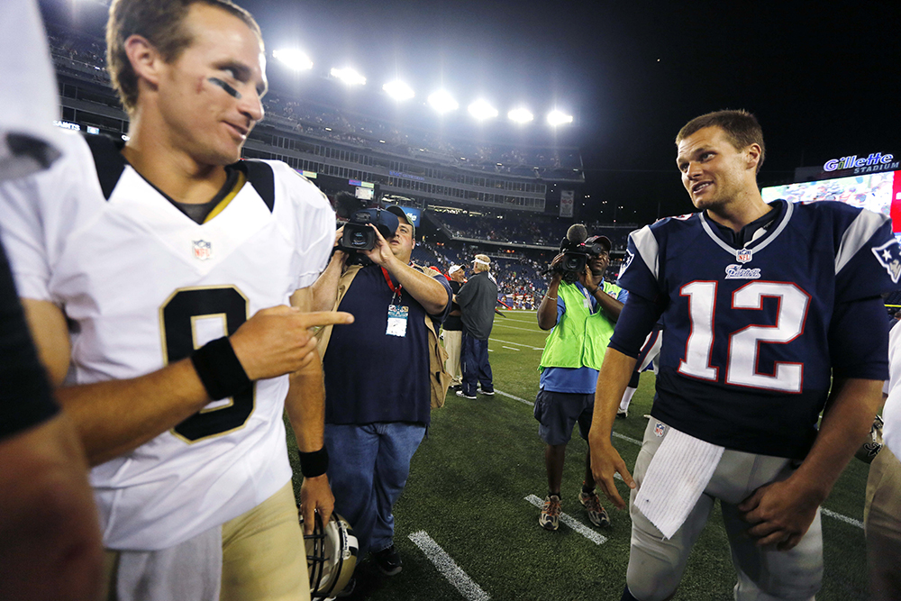 In this Aug. 9, 2012, file photo, New Orleans Saints quarterback Drew Brees (9) points at New England Patriots quarterback Tom Brady (12) after the Patriots defeated the Saints 7-6 in an NFL preseason football game in Foxborough, Mass.